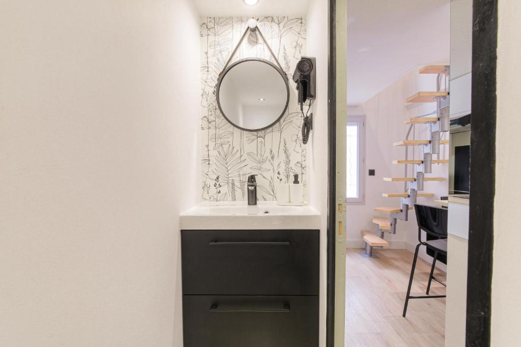 uma casa de banho com um lavatório e um espelho na parede em Tiny-duplex em Lyon