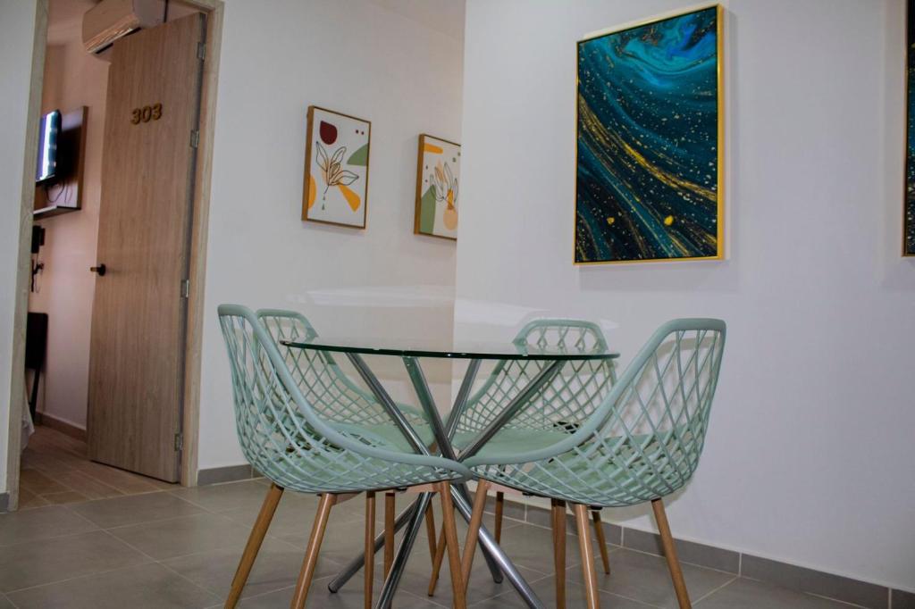 a dining room table with two chairs and a painting at GRAND HOTEL JAMUNDI in Jamundí
