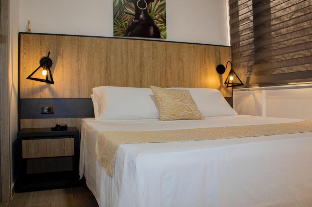 a bedroom with a large bed with two lights on it at GRAND HOTEL JAMUNDI in Jamundí