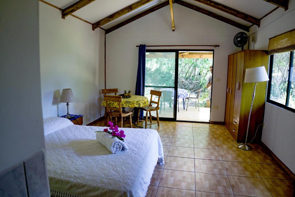 a bedroom with two beds and a table and chairs at Cabañas moeVarua en Tahai in Hanga Roa