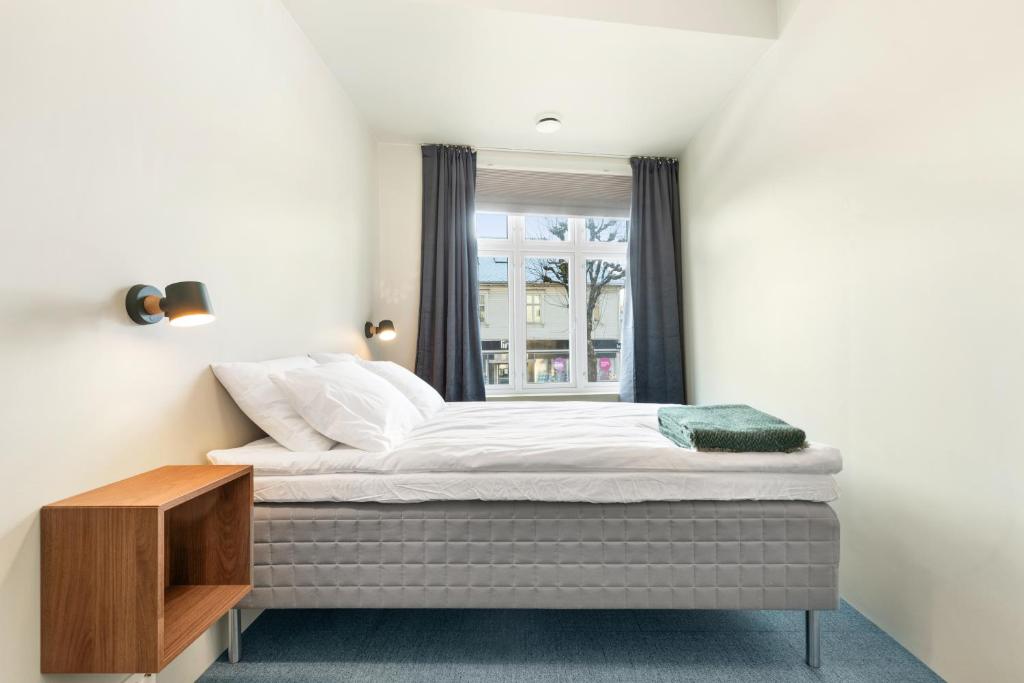 uma cama num quarto com uma janela em Central Guest House - Bedroom with private Bathroom em Stavanger