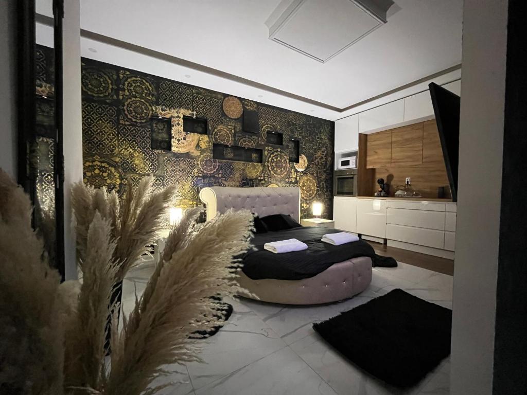a bedroom with two beds and a kitchen at Apartman Delux in Bačka Topola