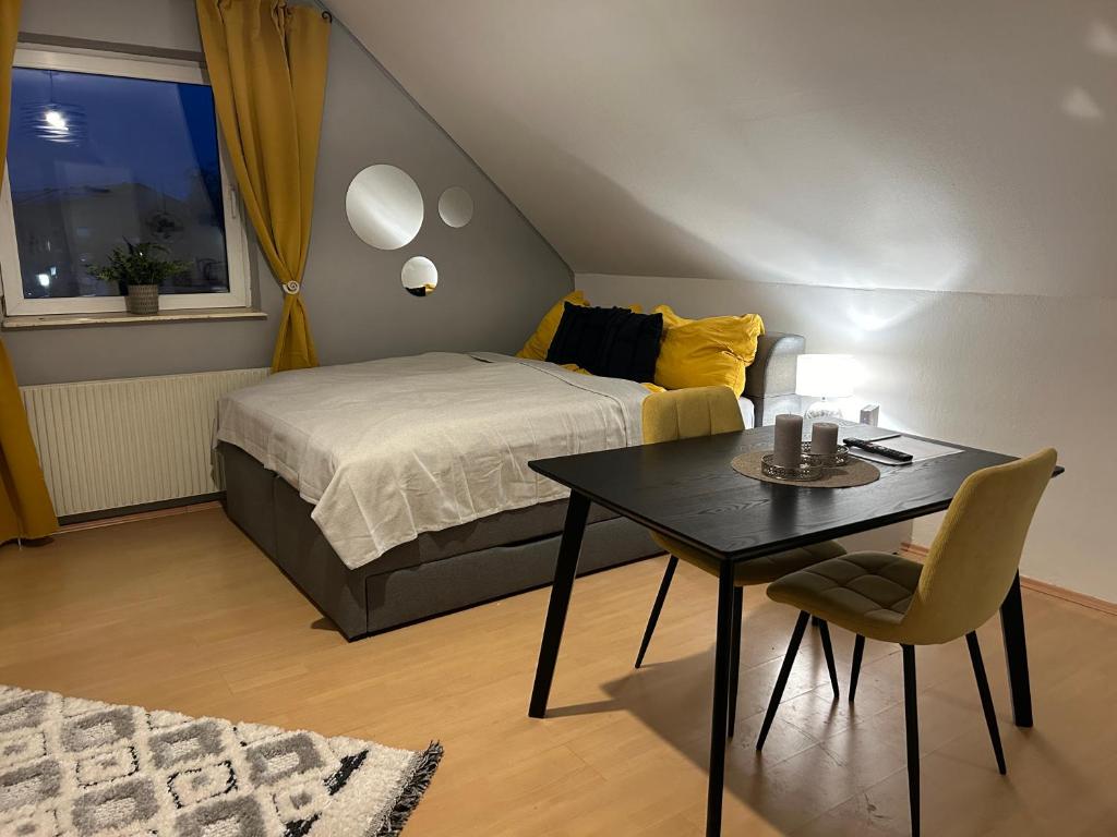 ein Schlafzimmer mit einem Bett, einem Tisch und einem Stuhl in der Unterkunft Gemütliche Garconniere im Zentrum von Pregarten in Pregarten