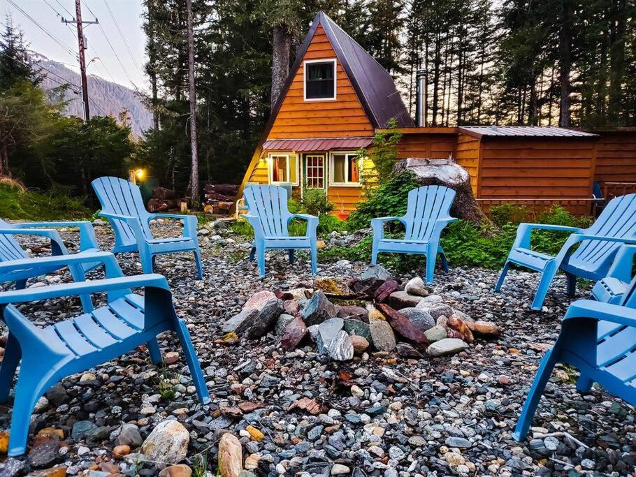 un grupo de sillas azules frente a una cabaña en Cabin & A-Frame w/ Firepit near Fishing & Trails en Juneau