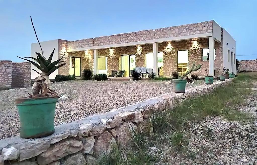 uma casa de pedra com vasos de plantas numa parede de pedra em Villa Boujmaa in Sidi Kaouki em Sidi Kaouki