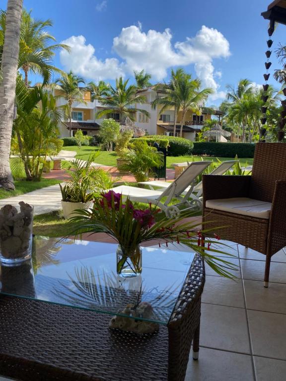 d'une terrasse avec une table, des chaises et des palmiers. dans l'établissement Esmeralda67 Tamarindo, à Bayahibe