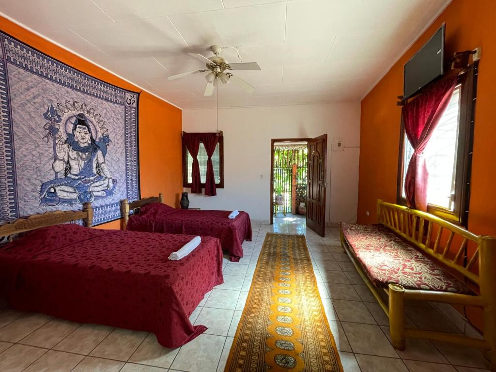 グラナダにあるCasa608の赤いベッドが備わるリビングルーム、壁に絵画が飾られています。