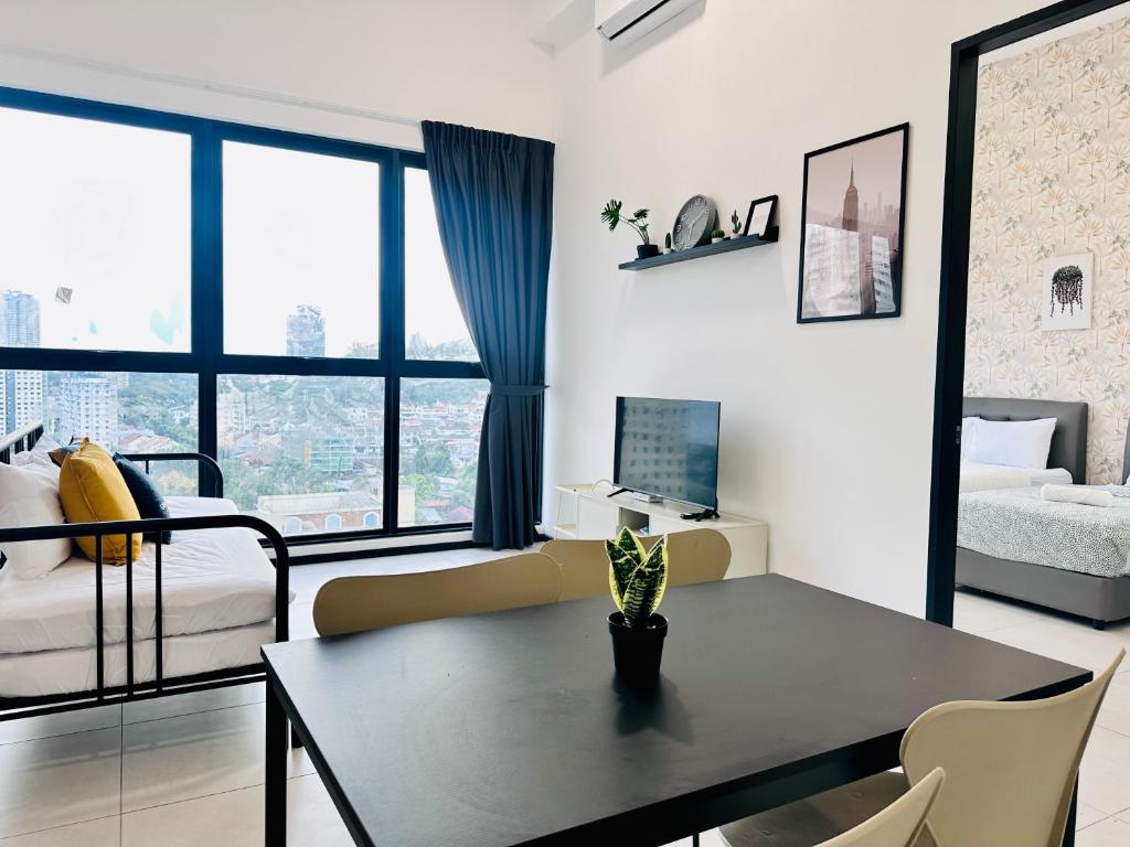 a living room with a table and a bedroom at New 2BR or 3BR Homey Getaway at Urban Suites, Georgetown 7 to 10pax in Jelutong