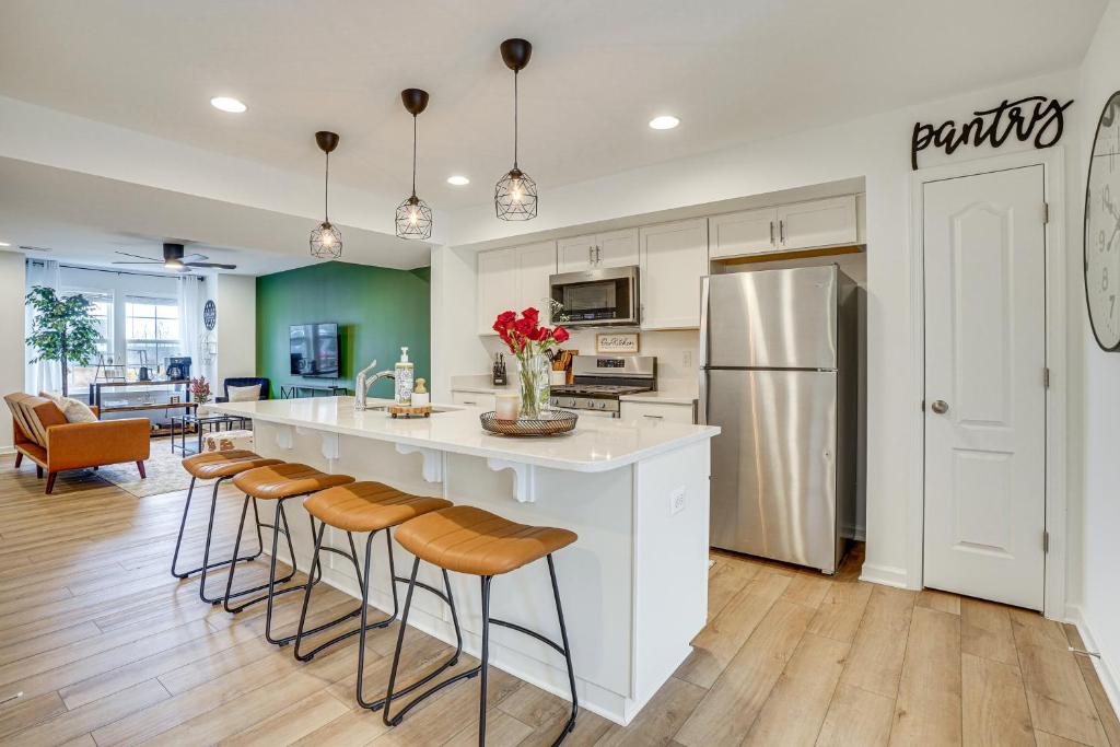 a kitchen with a white island with bar stools at Charles Town Townhome 9 Mi to Harpers Ferry in Charles Town