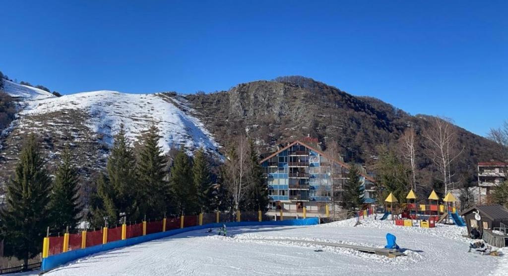 a snow covered mountain with a building and a resort at CASA VACANZA NIDO COLLETTO in Case Arfel
