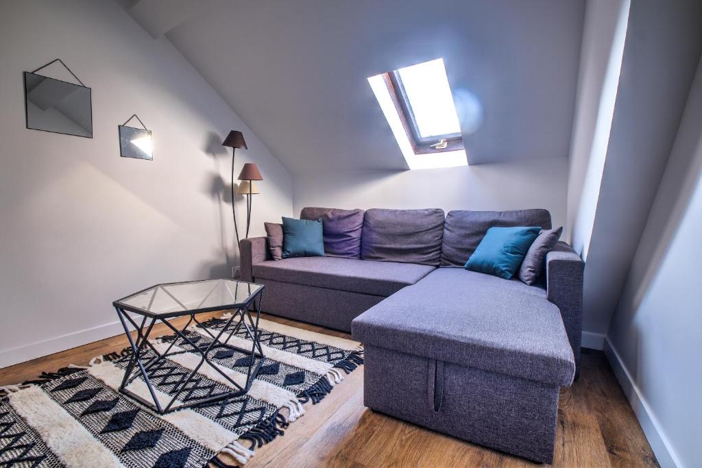 una sala de estar con un sofá y una mesa en Le St Martin, en Périgueux