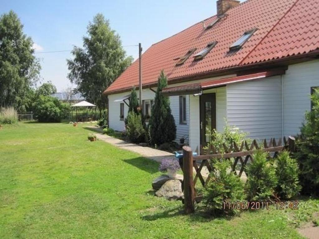 a white house with a red roof and a yard at Große Ferienwohnung in Dargen mit Grill in Dargen