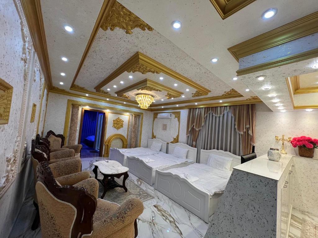Cette chambre comprend 2 lits et des chaises. dans l'établissement Hotel Premium, à Pristina