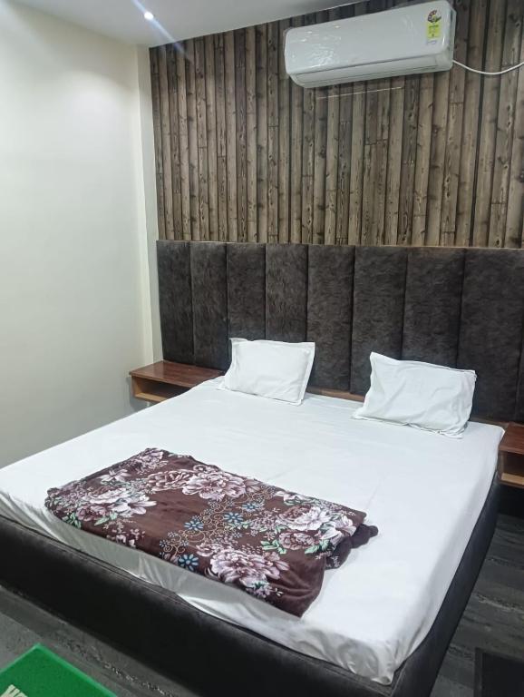 a bedroom with a bed with white sheets and a headboard at OYO Hotel Orvin In in Jabalpur