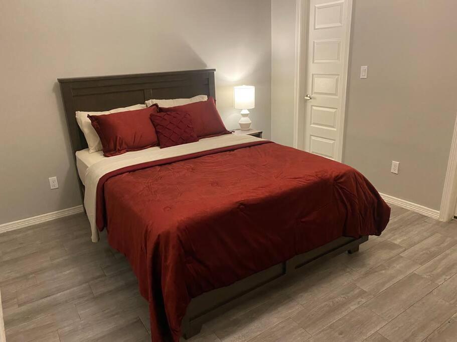 a bedroom with a large bed with red pillows at Spacious Getaway near UTRGV in Edinburg