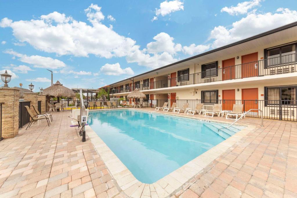 basen w hotelu z krzesłami i budynek w obiekcie Quality Inn Florida City - Gateway to the Keys w mieście Florida City