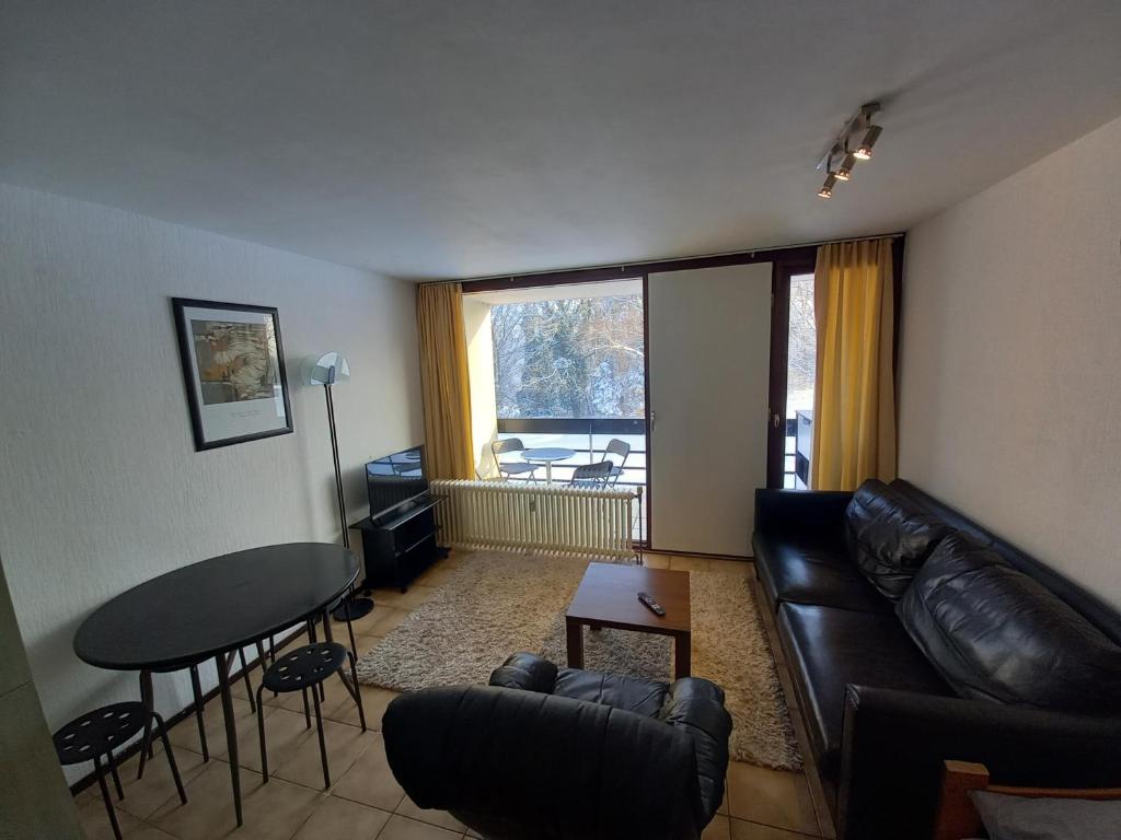 a living room with a leather couch and a table at Ap22 Nature Ardennes Economy class apartment in La Calamine