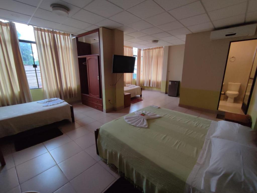 a hotel room with two beds and a television at JR HOTEL in Refineria Camiri