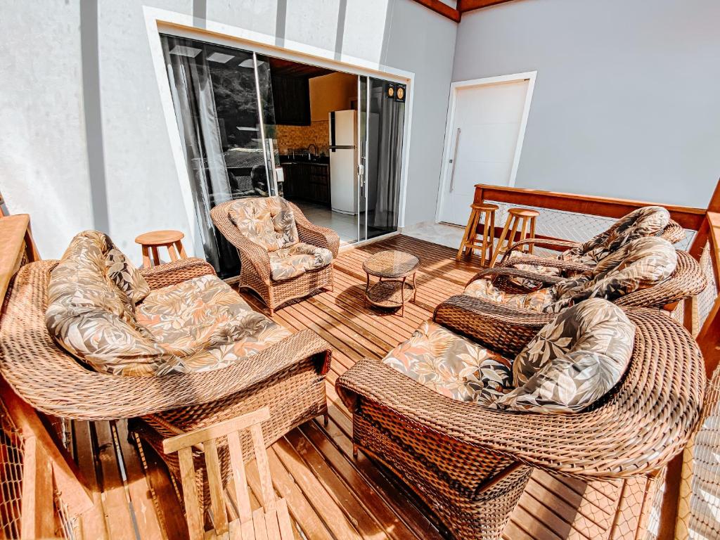 フロリアノポリスにあるMorada da Lagoinhaの木製デッキに籐家具が備わるリビングルーム