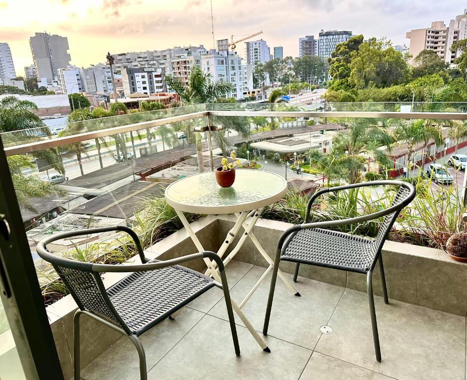 a table and chairs on a balcony with a view of a city at Apartamento con linda terraza in Lima