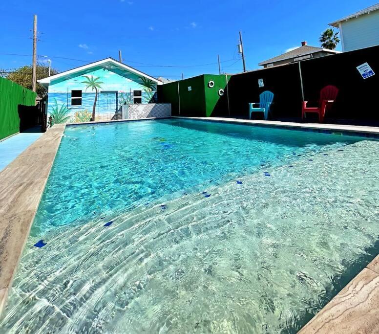 duży basen z czystą niebieską wodą w obiekcie The Poolside Bungalow w mieście Galveston
