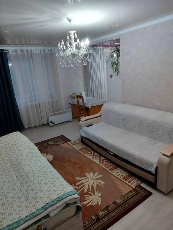 カラコルにあるErkina's - Beautiful Condo in downtownのリビングルーム(ベッド2台、シャンデリア付)