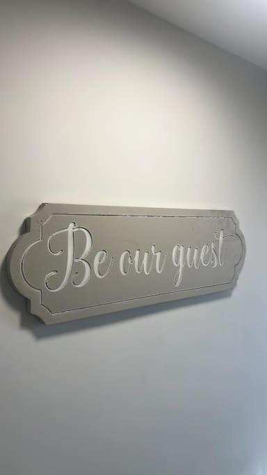 a sign that says be our guest on a wall at Westland Suites - Stylish, Modern, Elegant, Central Apartments in Londonderry County Borough