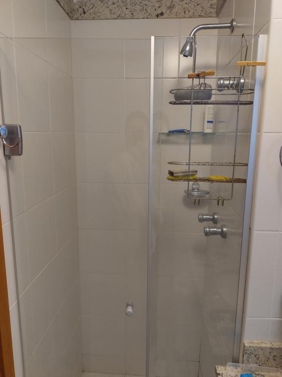 uma casa de banho com um chuveiro e uma porta de vidro em Apato Recreio no Rio de Janeiro