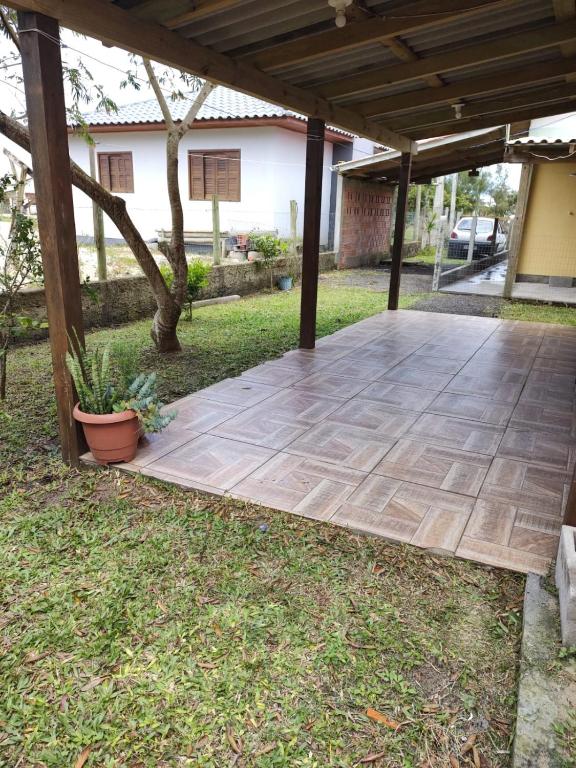un patio sotto un tetto con piante sull'erba di Casinha paz e descanso a Balneário Gaivotas