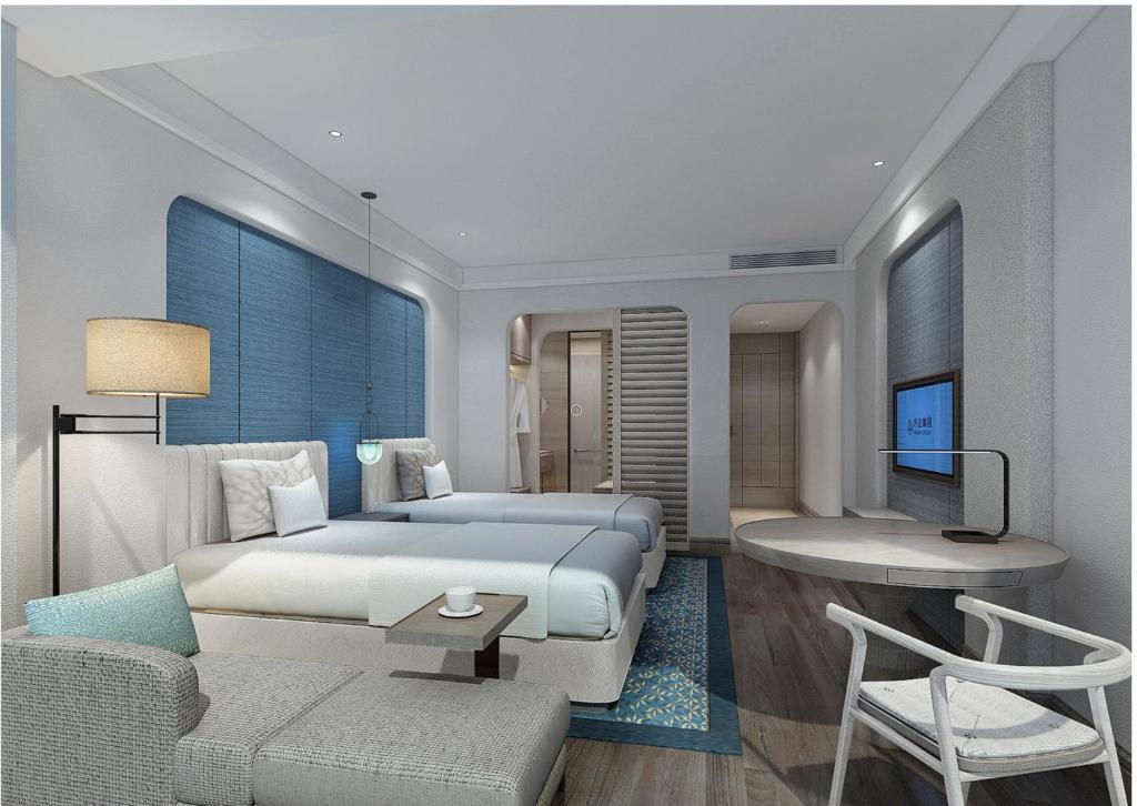 una camera con letto, scrivania e divano di Crowne Plaza QingdaoOrientalMovieMetropolis, an IHG Hotel a Huangdao