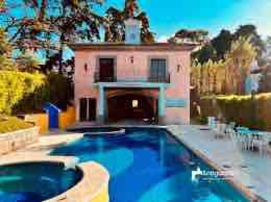a large swimming pool in front of a house at Acogedora casa con firepit in San Juan del Obispo