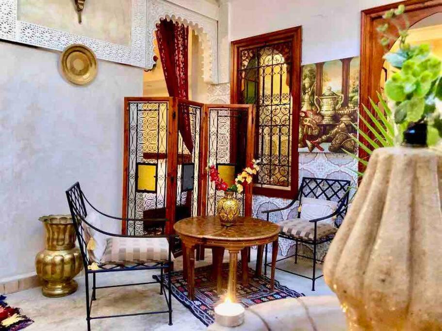 a living room with a table and chairs at Dar El Jazouli in Marrakesh