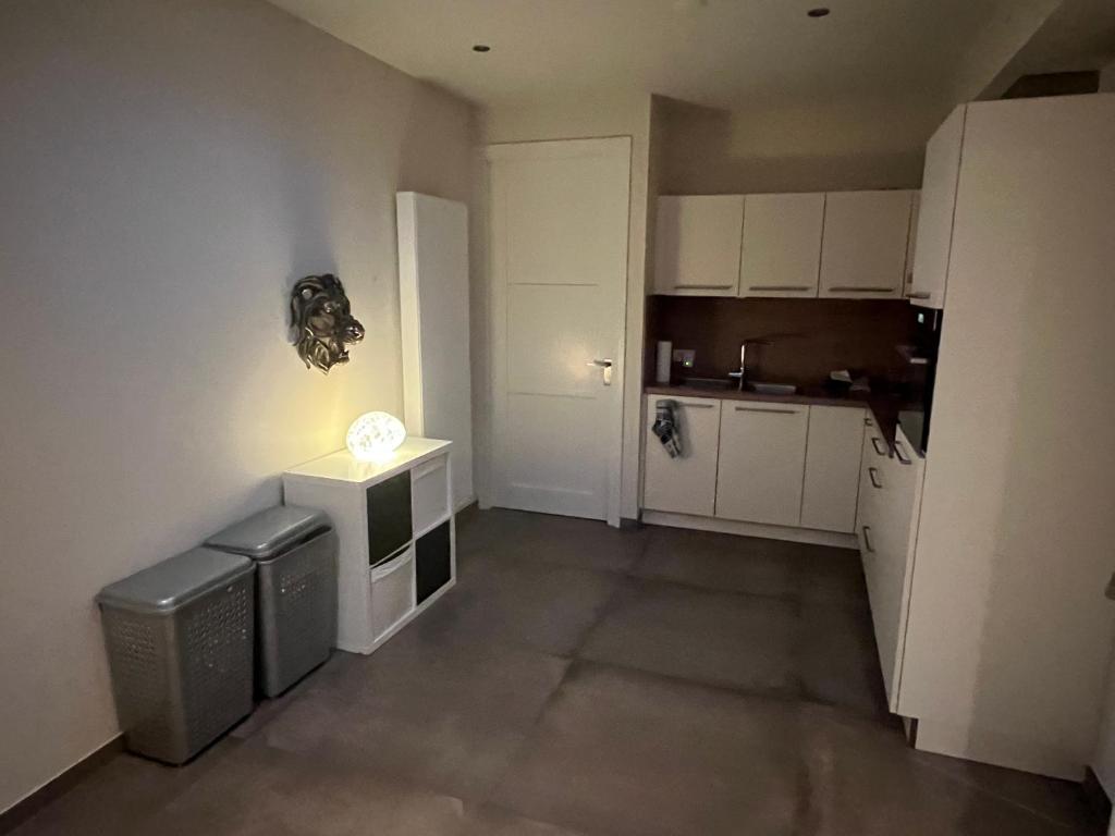 uma pequena cozinha com armários brancos e um balcão em Apartment Venlose heide em Venlo