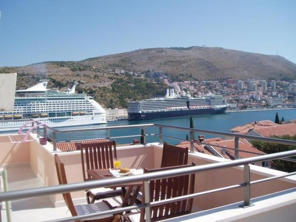 een balkon met 2 stoelen en cruiseschepen in het water bij Ferienwohnung für 3 Personen 1 Kind ca 75 qm in Dubrovnik, Dalmatien Süddalmatien in Dubrovnik