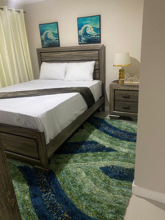 um quarto com uma cama com um tapete verde em Finest Accommodation Bay Front Villa G9 em Portmore