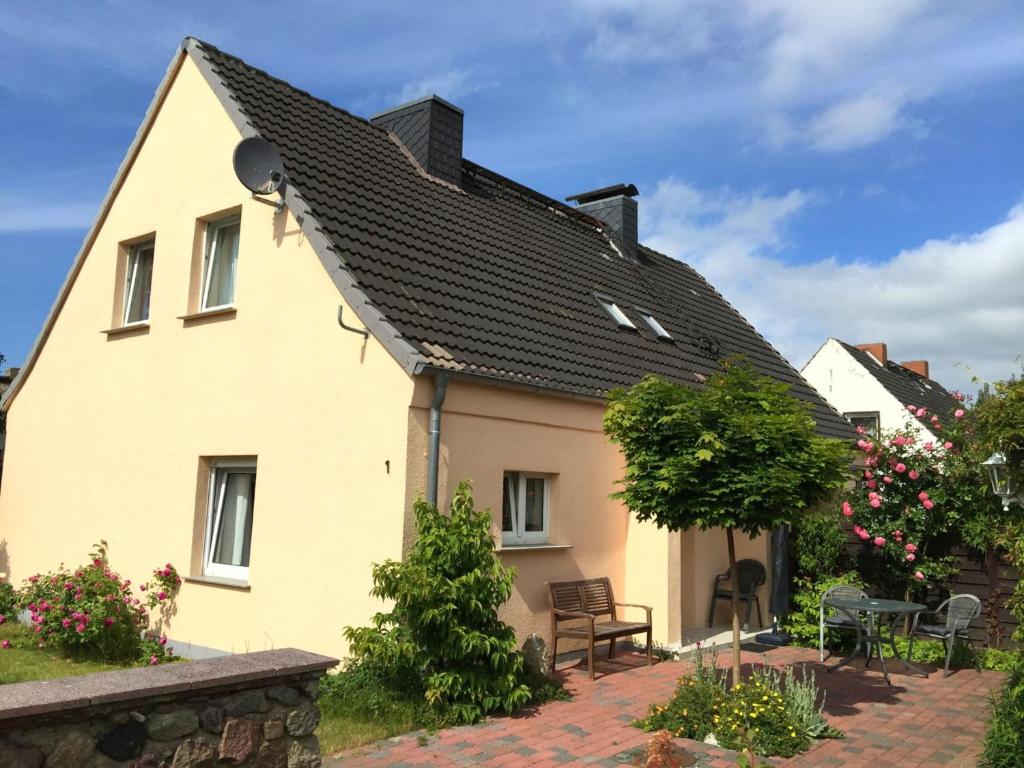 ein gelbes Haus mit schwarzem Dach in der Unterkunft Ferienhaus in Bartelshagen II in Hessenburg