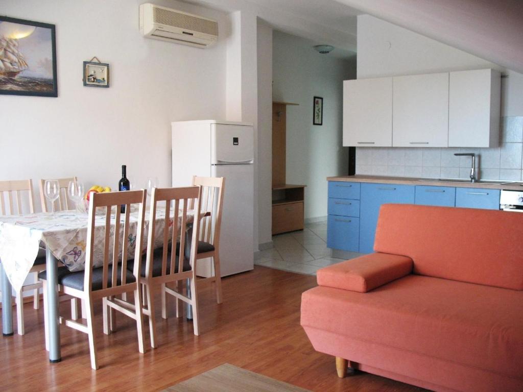 - une cuisine et une salle à manger avec une table et un canapé dans l'établissement Apartment mit Balkon, à Petrčane