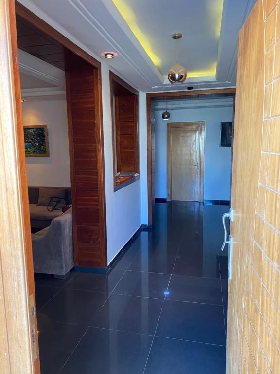 a hallway with blue walls and a tile floor at Villa El mansoura S+3 in Kelibia
