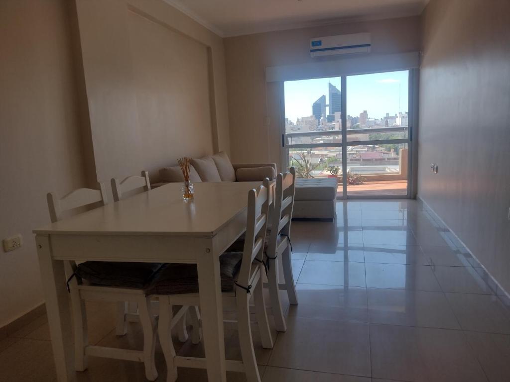 d'une salle à manger avec une table, des chaises et une fenêtre. dans l'établissement Departamento moderno para 2 personas, à Santiago del Estero
