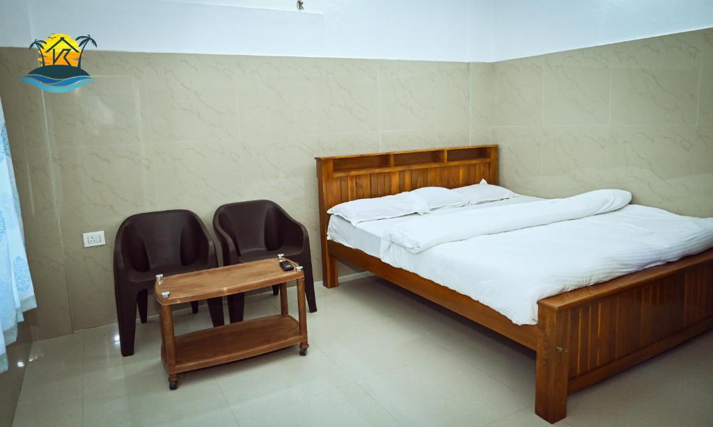 a bedroom with two beds and a table and two chairs at Holiday home stay in Malpe