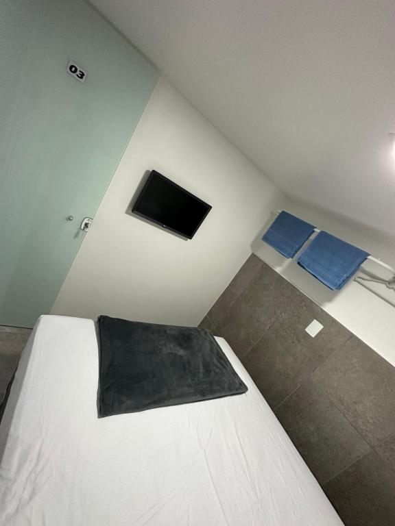 a bedroom with a bed and a tv in it at Quarto privativo com banheiro compartilhado,a 800mts do pátio do forró in Caruaru