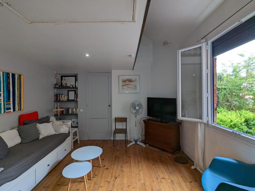 un salon avec un canapé et une télévision dans l'établissement Appartement Calme au Centre d'Arcachon, Proche Plages, Commerces et Gare - FR-1-420-134, à Arcachon