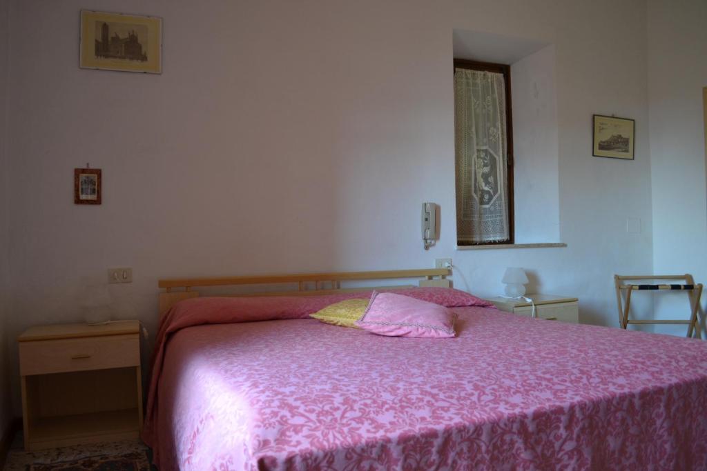 a bedroom with a bed with a pink blanket at Da Bianchina in Capanne