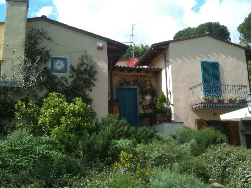 una pequeña casa blanca con una puerta azul en B&B Pino del Capitano, en Dicomano