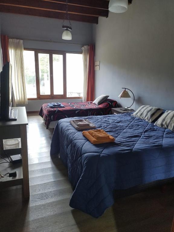 a bedroom with two beds and a television in it at Ananda in Ushuaia