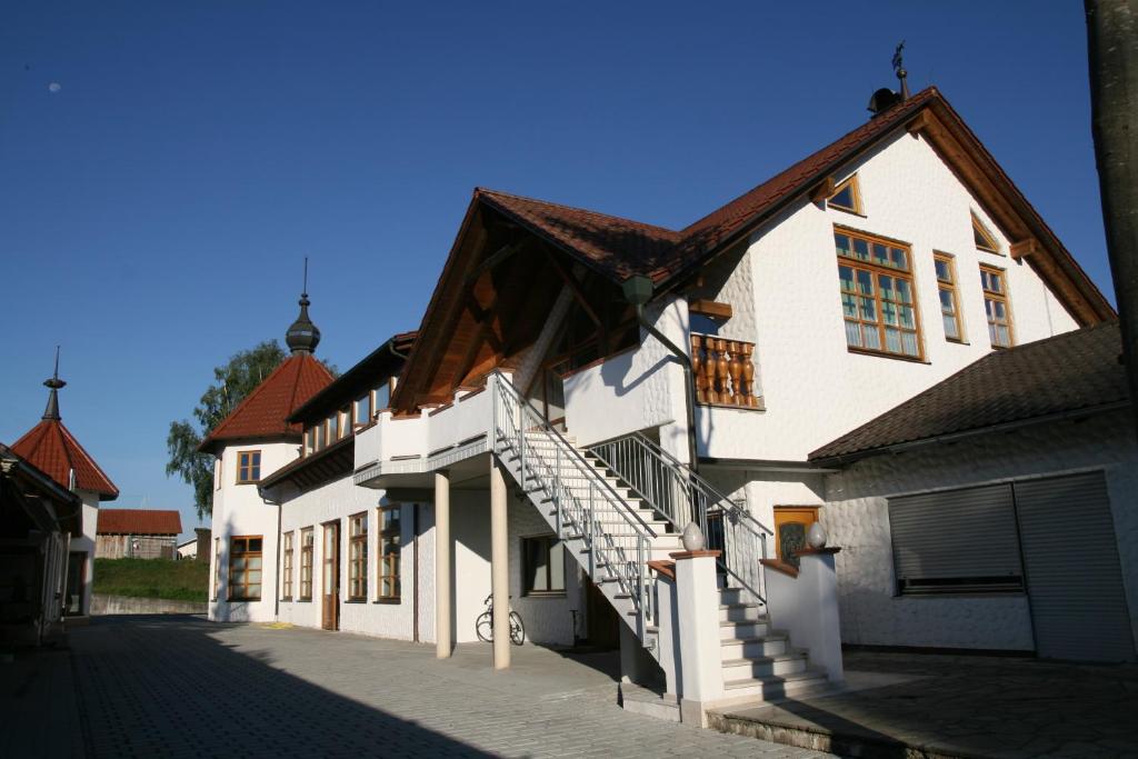 a white building with a staircase on the side of it at Ferienwohnung Gmeinwieser in Mitterfecking