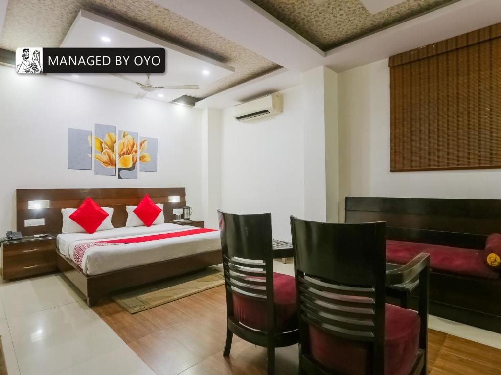 a bedroom with a bed and a table and chairs at Super OYO Chand Palace - Managed by Company in New Delhi