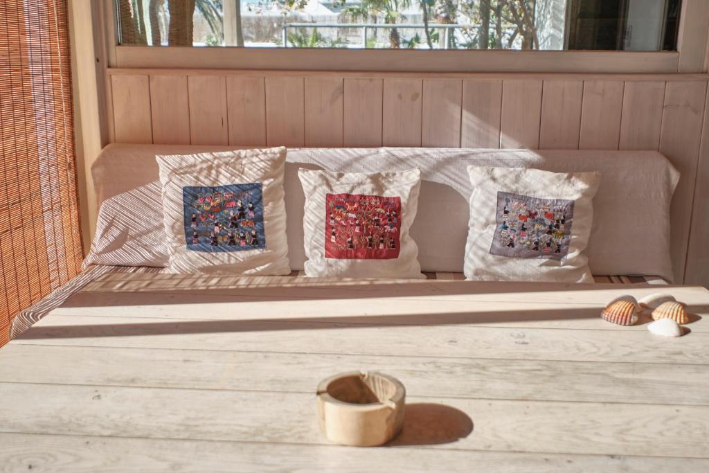 a bed with four pillows on it with a window at Bolonia Beach Campus in Tarifa