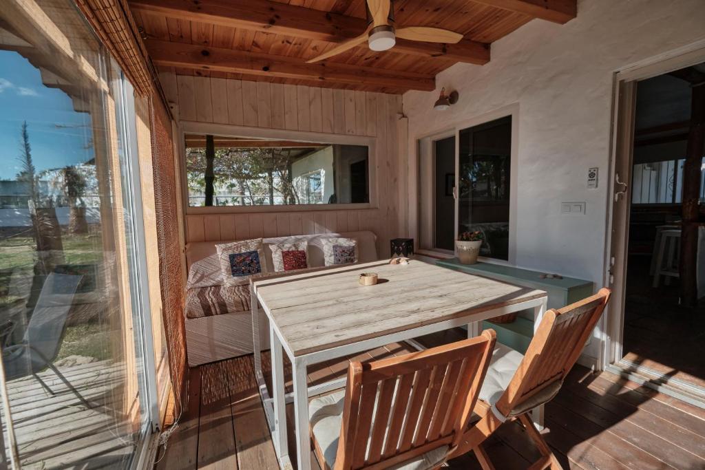 a porch with a wooden table and chairs at Bolonia Beach Campus in Tarifa
