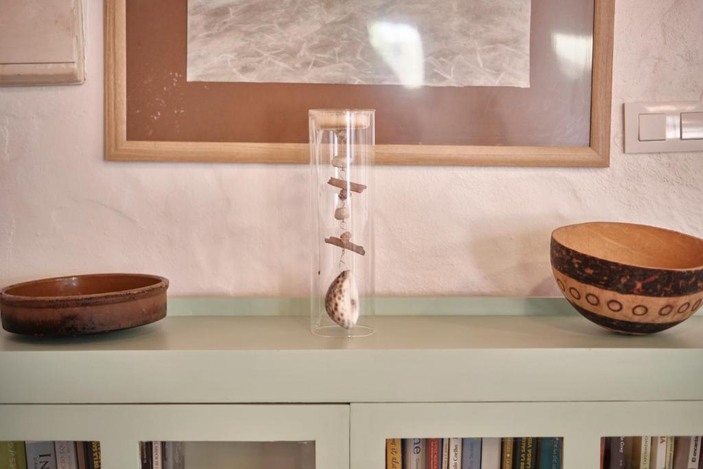 a glass vase on top of a shelf with two bowls at Bolonia Beach Campus in Tarifa